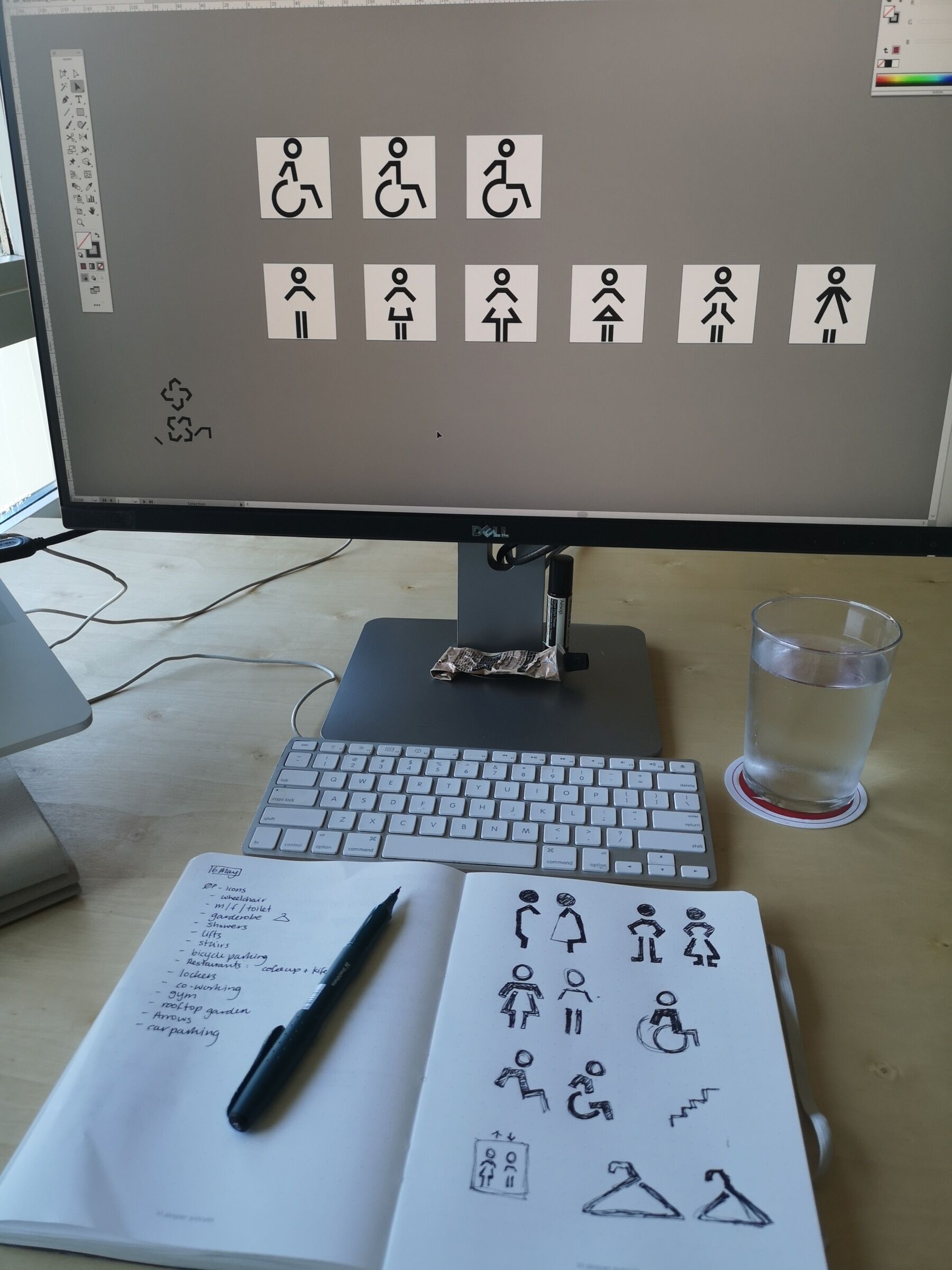 Skissebok med eksempler / tester på grafiske uttrykk. Mac i bakgrunn der eksemplene er skissert på data. Foto