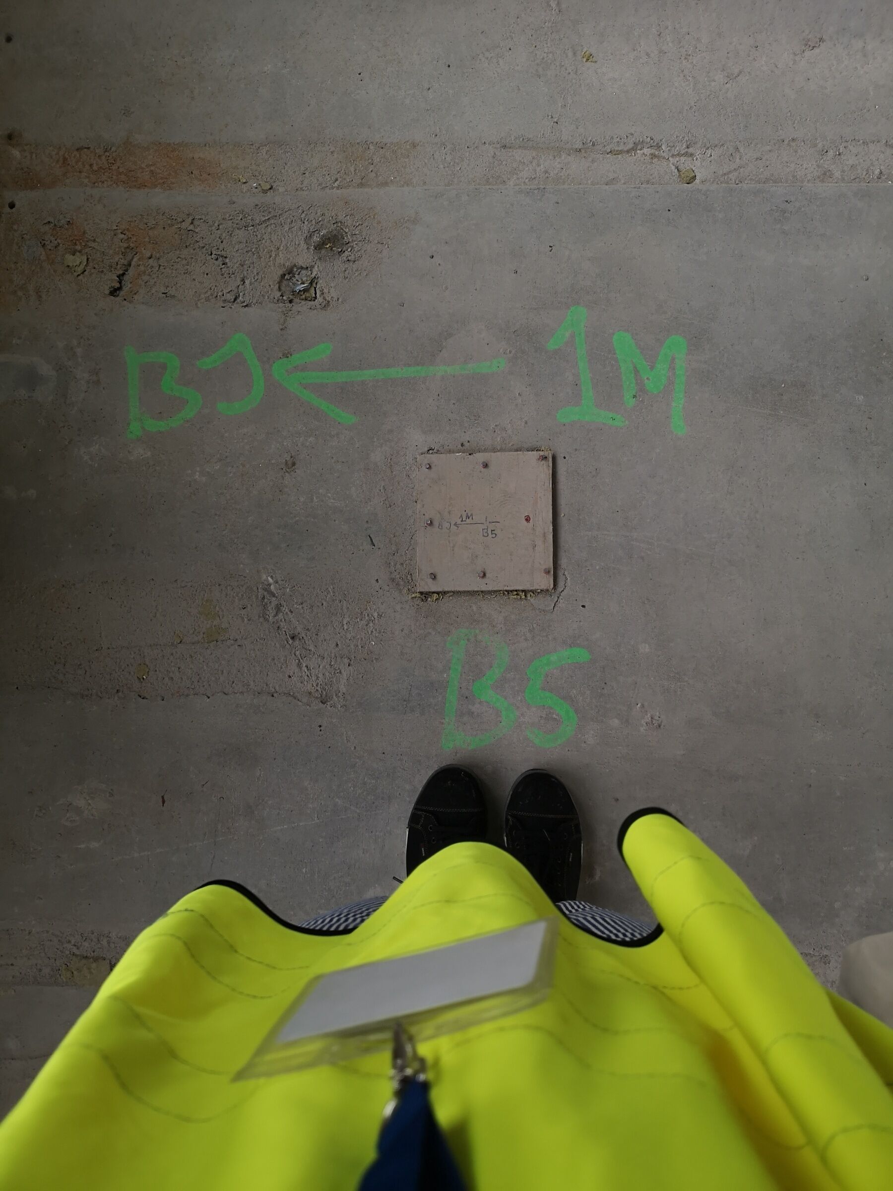 Person tar bilde ned i et betonggulv. Foto