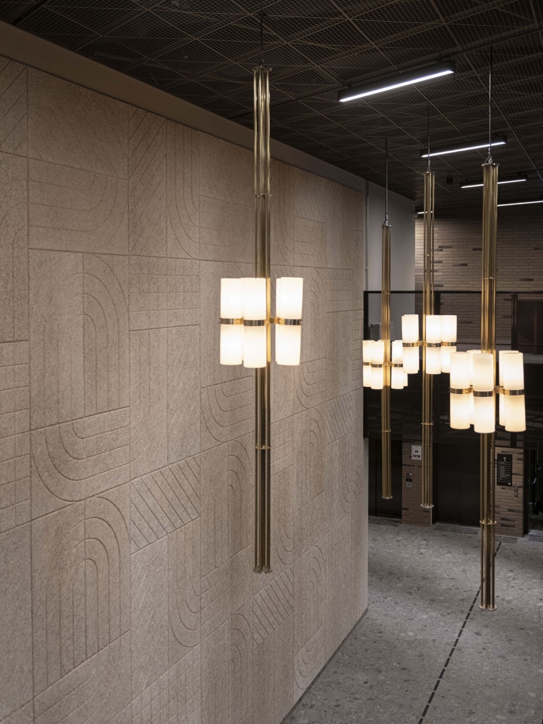 Fore store lamper henger fra tak i et åpent rom. Foto.